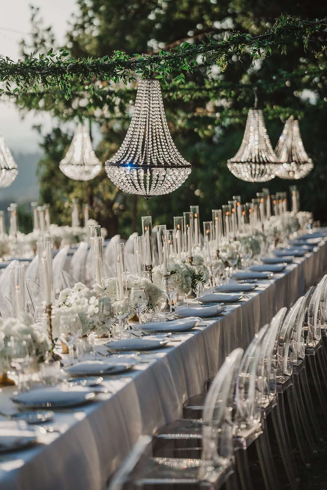 Langer eleganter eingedeckter Hochzeitstisch mit Kronleuchtern