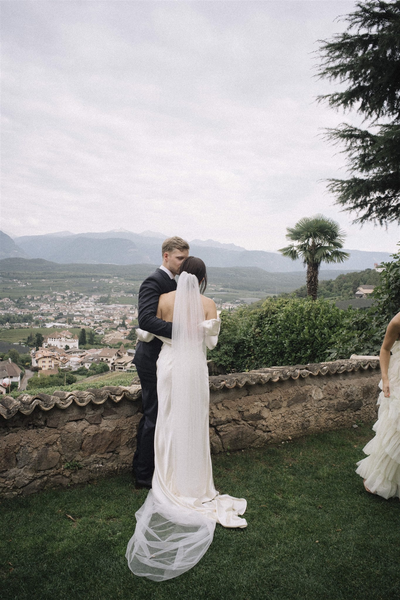 Hochzeitspaar in einer romantischen Umarmung mit Ausblick auf eine weite Landschaft im Hintergrund.