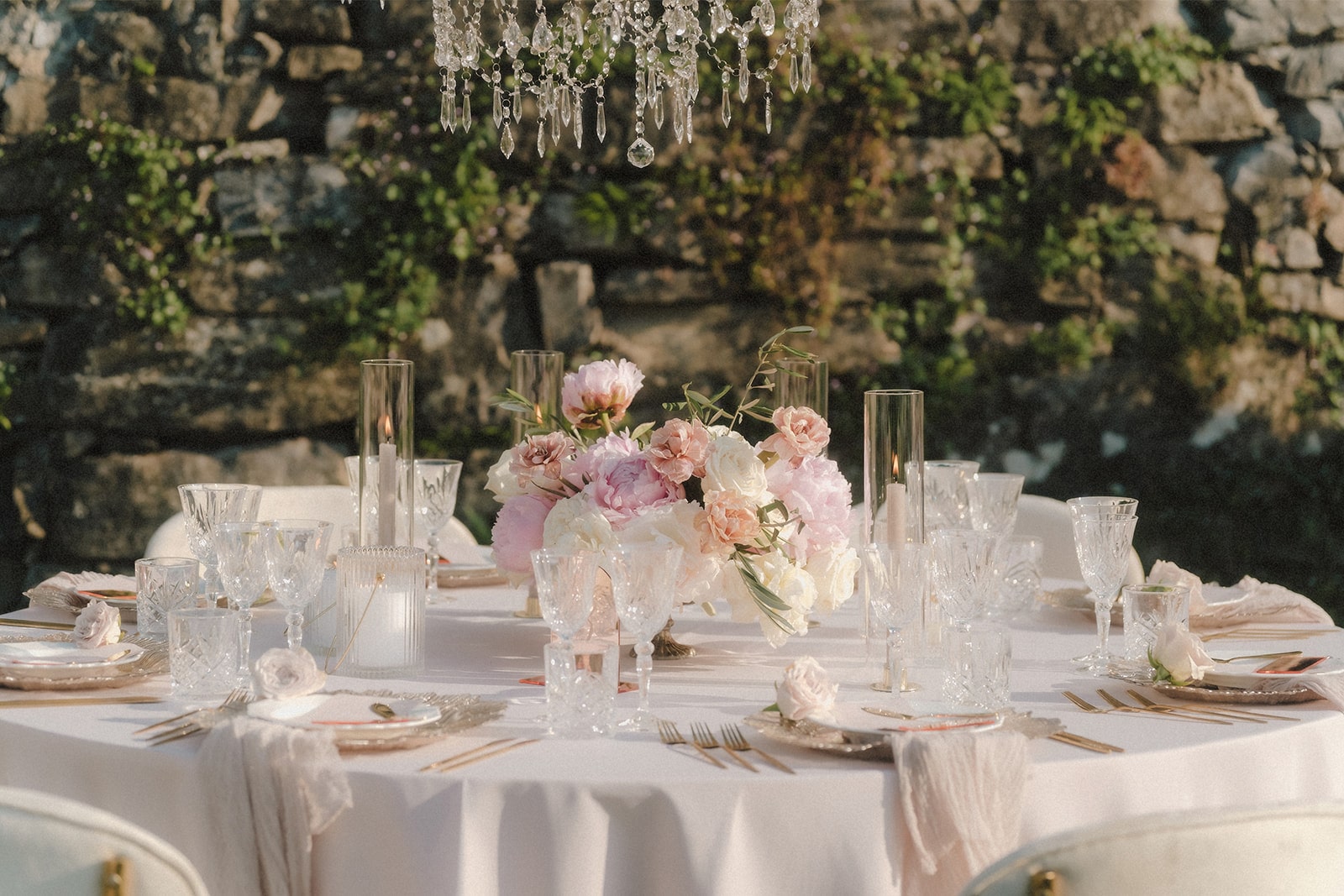 Nahaufnahme einer eleganten Hochzeitstafel mit Kristallgläsern und Blumenarrangements am Lake Como.