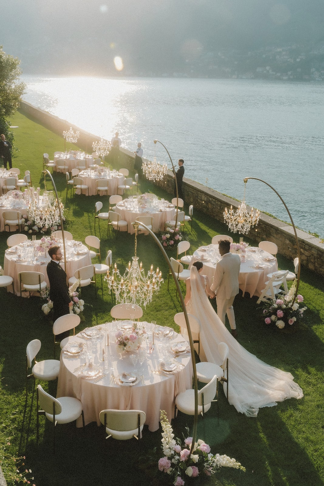 Das Brautpaar bewundert die elegante Outdoor-Hochzeitsdekoration bei Sonnenuntergang am Lake Como.