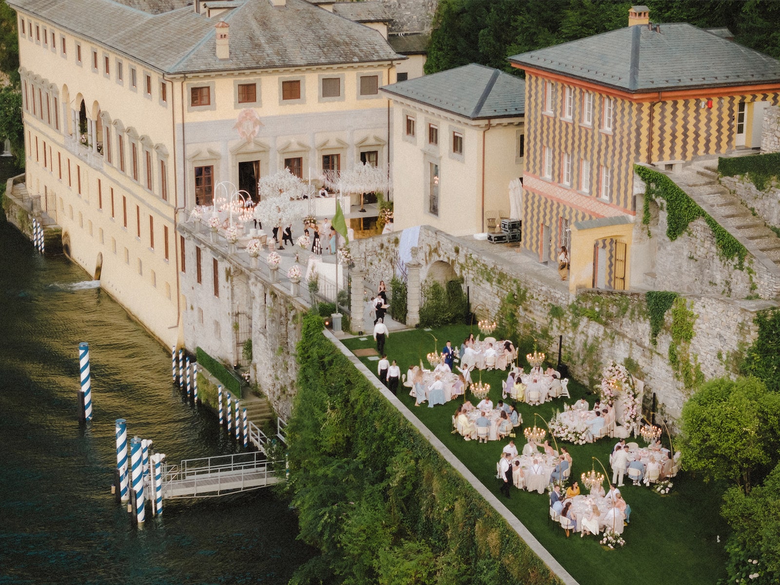 Luftaufnahme einer exklusiven Hochzeitslocation am Lake Como mit historischen Villen und festlicher Dekoration.