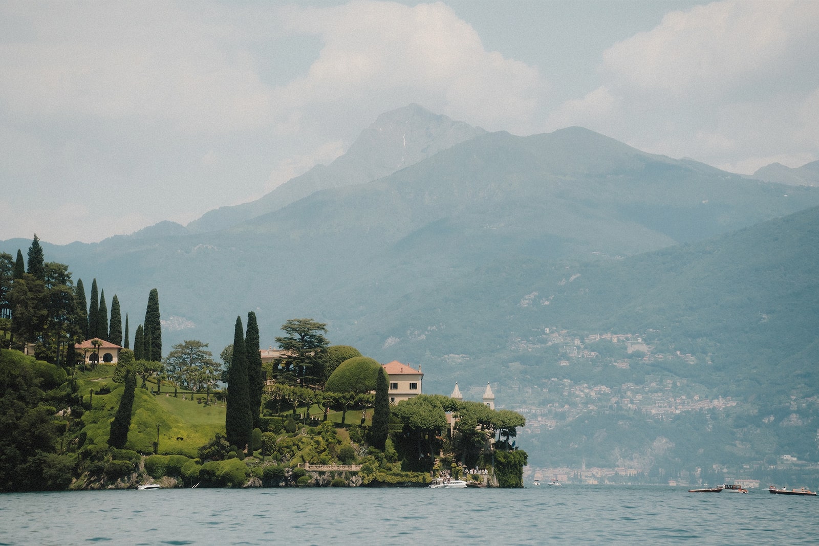 Panoramablick auf die idyllische Landschaft des Lake Como mit historischen Villen und grünen Bergen.