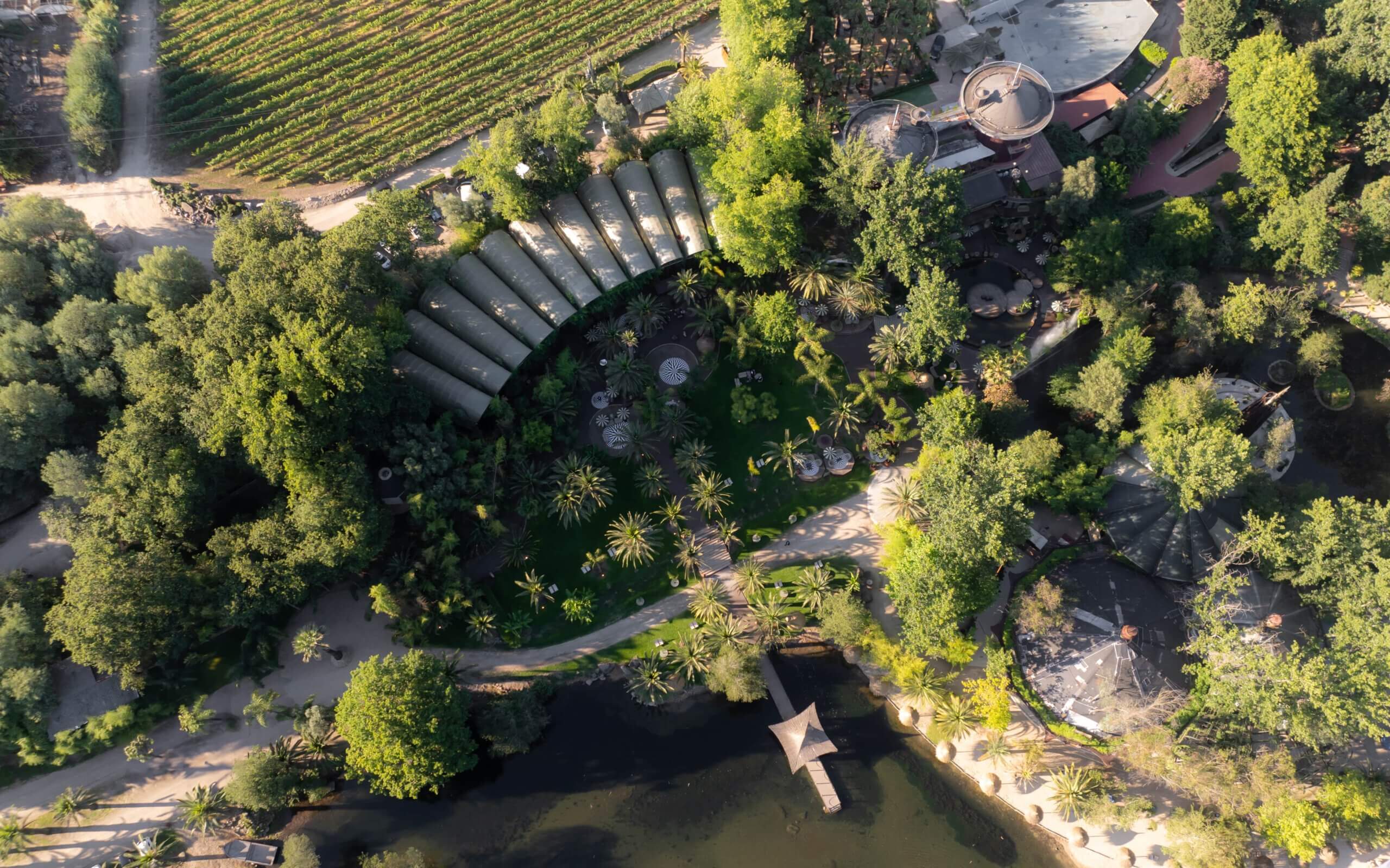 Luftaufnahme einer luxuriösen Outdoor-Hochzeitslocation in Portugal mit üppigen Grünflächen und eleganten Strukturen, die eine exklusive Atmosphäre schaffen.